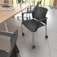 Santana 4 leg mobile chair with plastic seat and perforated back and black frame with castors and arms and writing tablet - grey
